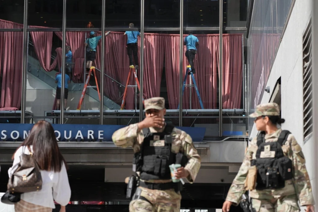 Workers hang draperies inside Madison Square Garden ahead of the wedding of Taylor Swift and Travis Kelce as members of the armed forces stand outside. in New York City, July 2, 2026.